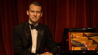 Photo of Joseph Kingma seated at a piano